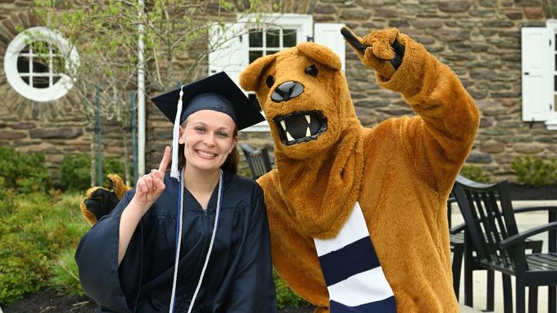 Nittany Lion mascot and female graduate outdoors